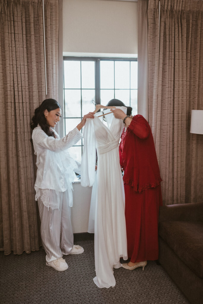 A mother and bride admiring her wedding dress.