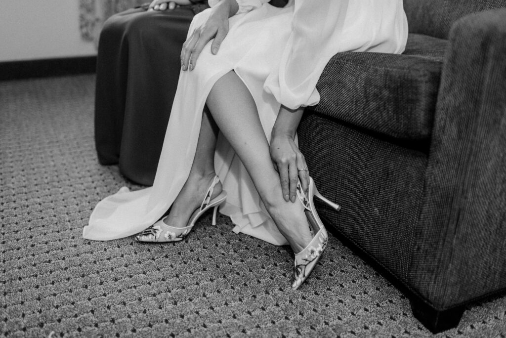 A bride putting on her wedding shoes. 