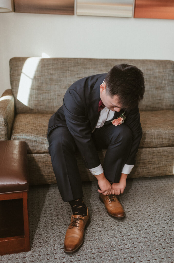 A groom tying up his shoes.