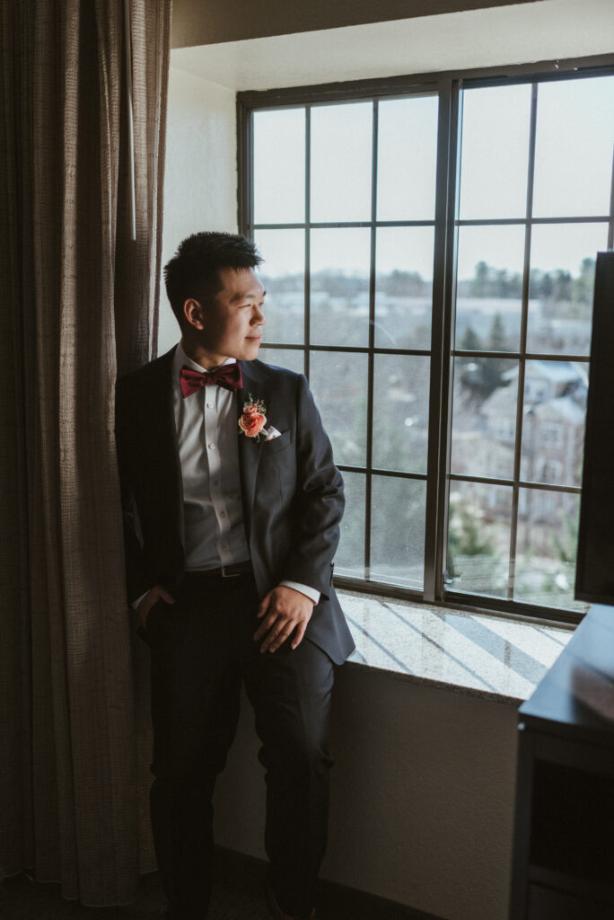 A groom sitting in a window sill. 