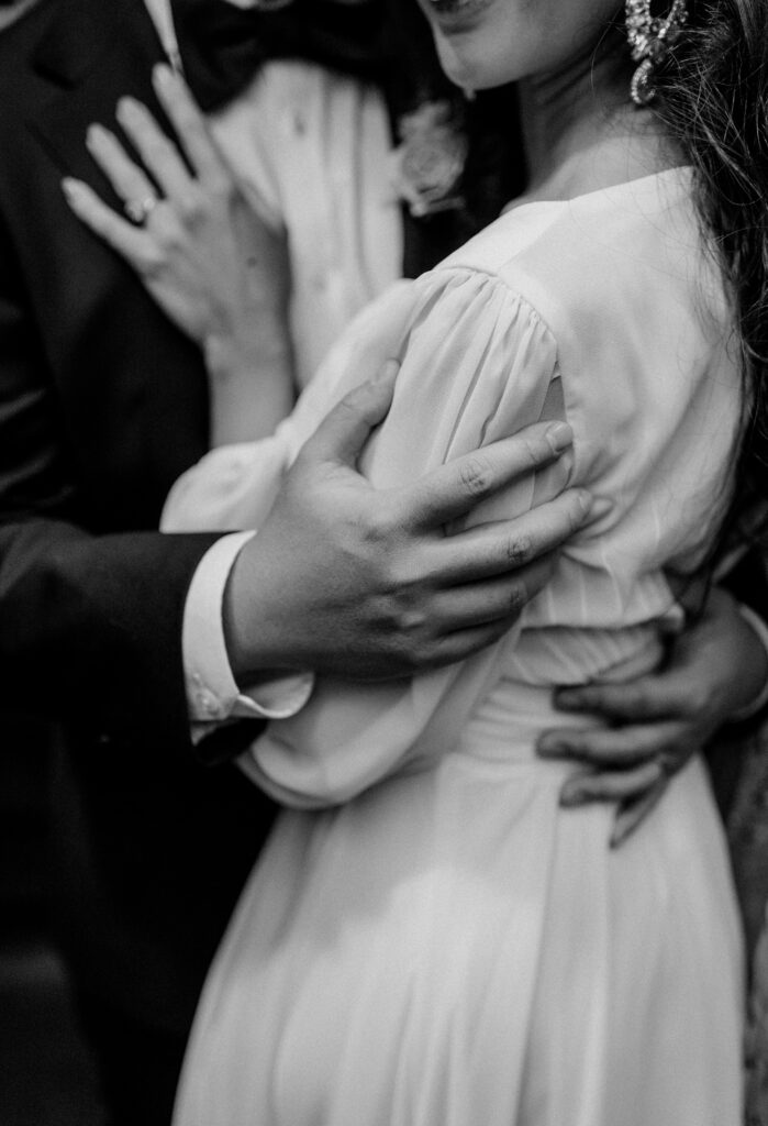 Close up of a bride and groom embracing.