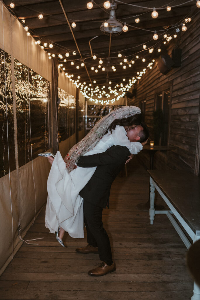 A groom lifts his bride up in the air at Terrain at Styers wedding venue.