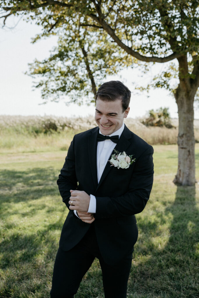 Groom smiling in anticipation of seeing his bride for the first time.