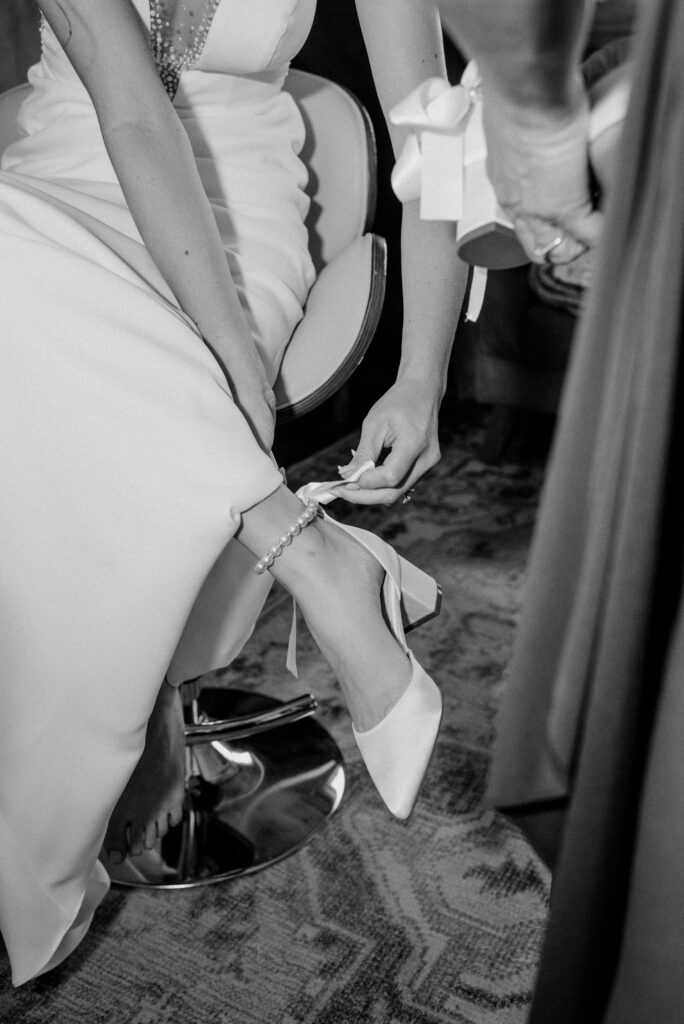 Detail of bride putting her heels on.