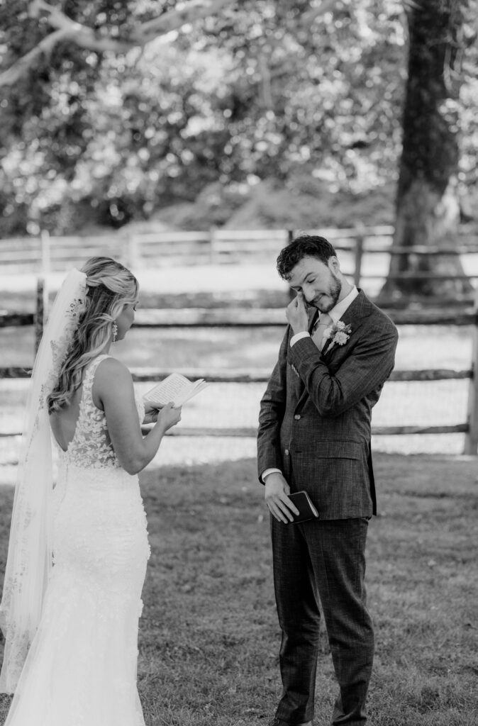 Groom wiping a tear away during private vows with his bride at Inn at Grace Winery in Glen Mills, PA