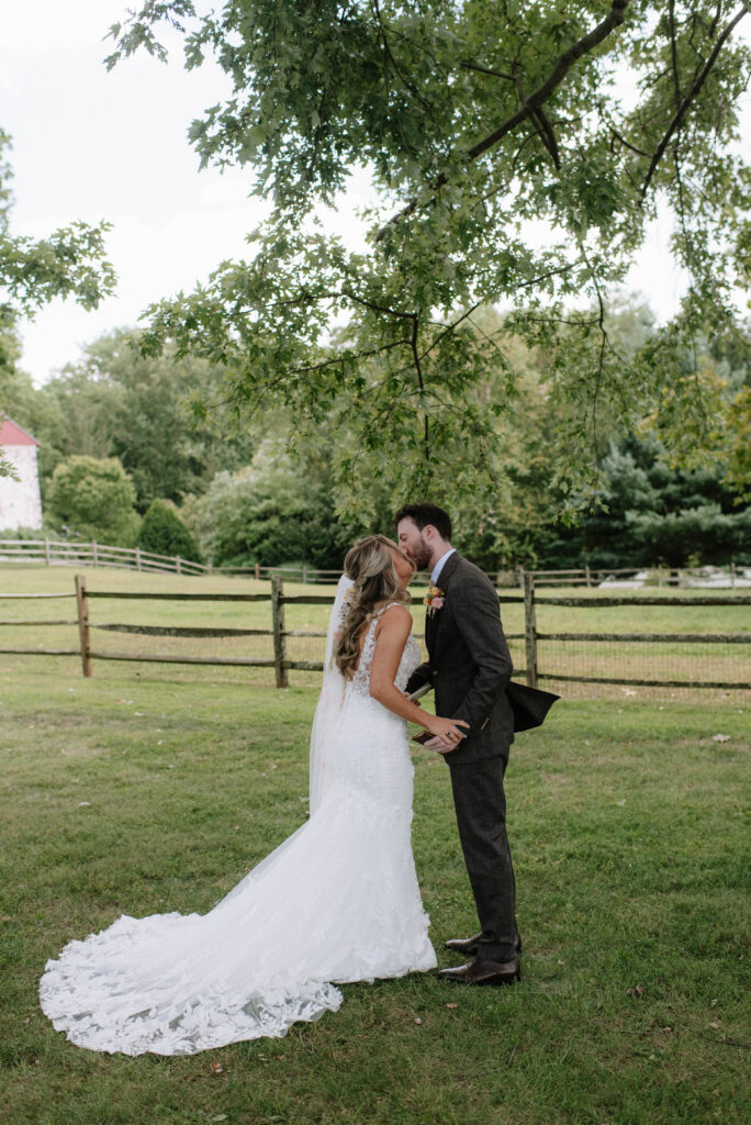 Bride and groom kiss after their first look at the Inn at Grace Winery in Glen Mills, PA
