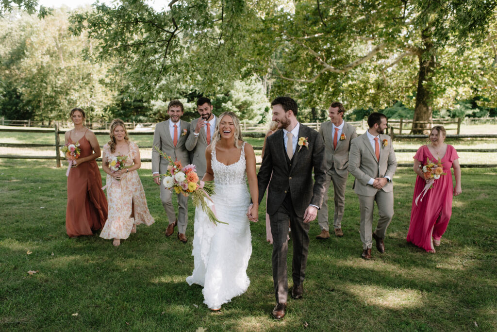 Wedding party walking and laughing at Inn at Grace Winery in Glen Mills, PA.