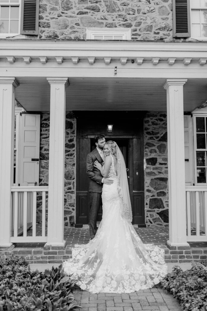 Bride and groom on porch at the Inn at Grace Winery in Glen Mills, PA. 