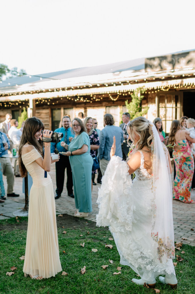 Bride shows of her rings for her wedding guest who is using a camcorder to document her wedding day at Terrain Gardens at Styers in Glen Mills, PA!